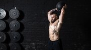 Sweaty muscular fit man performing hiit medicine ball workouts