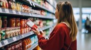 Young woman shopping for healthy foods and reading the labels to avoid ultra-processed foods