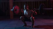 Physically fit man performing a behind the neck squat using the Contrast Set Training method