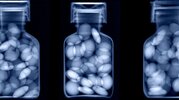 A blue-tinted x-ray of pills in a bottle