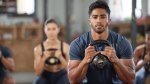 Fit man demonstrating the benefits of kettlebell training in a group kettlebell workout session