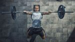 Fit man practicing the priming training method for a barbell bench press exercise and workout