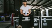 Counrty music star Chase Rice resting on speaker suitcase