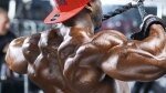 Black bodybuilder doing deltoid shoulder exercise with cable rope machine