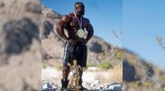 2024 Mr. O Samson Duada posing in the desert with his Mr. Olympia Medal and trophy