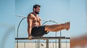 Aaron Rodgers performing left lift dips outdoors on a beach