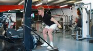 Young muscular blonde man demonstrating ski erg workouts