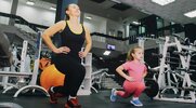 Mother and daughter working out in the gym to spring back in shape