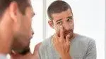 pplying-Lotion-To-His-Face-While-Looking-In-Mirror.webp