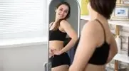 ung-Female-Fitness-Gear-Checking-Herself-In-Mirror.webp