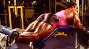 Lee-Haney-performing-leg-curls-exercise-at-the-gym.webp