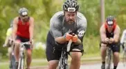 -Cottrell-riding-his-road-bike-with-a-biking-group.webp