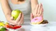 Female-Pushing-Away-Plate-of-Donuts.webp