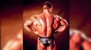 -Dorian-Yates-back-muscles-doing-a-lat-spread-pose.webp