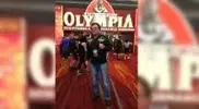 z-posing-in-front-of-the-Mr.-Olympia-weekend-event.webp