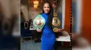 xi-dress-and-holding-her-championship-boxing-belts.webp