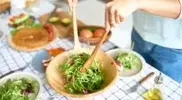 Female-Serving-Salad-From-A-Wooden-Bowl.webp