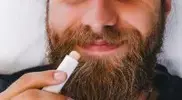 Bearded-Man-Applying-Lip-Balm-To-His-Lips.webp