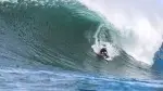 Surfer-Koa-Smith-riding-a-wave-through-the-pipe.webp