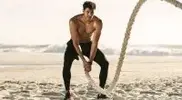 Fit-Man-Working-Out-On-The-Beach-With-Battle-Ropes.webp