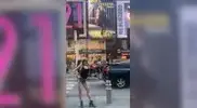 -Collins-in-Times-Square-pointing-at-her-billboard.webp