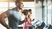 Group of fit people running on a treadmill and doing a cardio workout