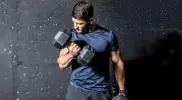 Bodybuilder doing a workout for biceps with dumbbell curls exercise