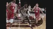 Basketball player driving to the net with two defenders covering him