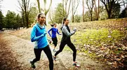 Three female triathletes training for a triathalon and using running tips to stay comfortable while running in the woods