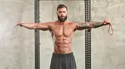 Muscular man performing banded exercises using a resistance band to improve his deadlift