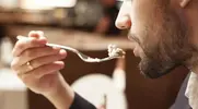 Hungry man eating tuna with a fork