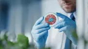 Scientist holding a petri dish of Plant-Based Meat Alternatives labeled for vegans