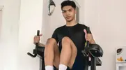 Asian male performing a Captain's Chair exercise to strengthen his abs