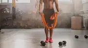 Fit man setting up for a chaos training session using bands and dumbbells