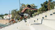 Strong black athlete using plyometric training to jump high on the stairs