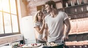 Loving couple cooking a meal in a fancy home kitchen