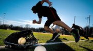 Baseball players sprinting on a baseball field for their spring strength training routine