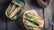 Canned-Sardines-On-Plate-Rustic-Wooden-Table