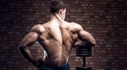 Fit and strong man performing a resting next to a heavy weight dumbbell for a dumbbell back workout