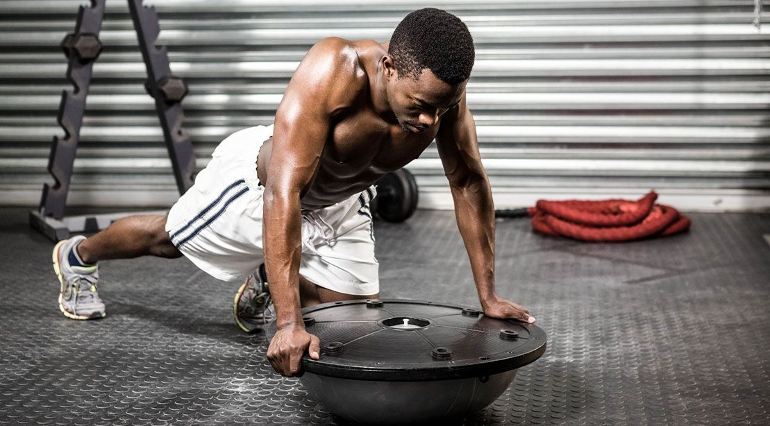 Young fit black male working out with a bosu ball exercise